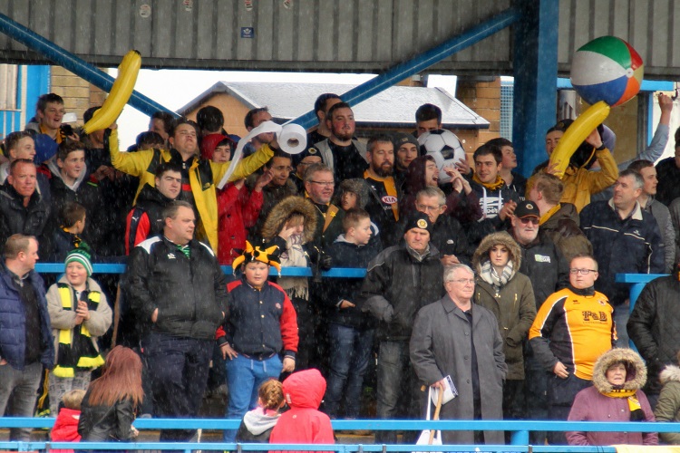 The Boston fans keep warm during the pre-match hail shower