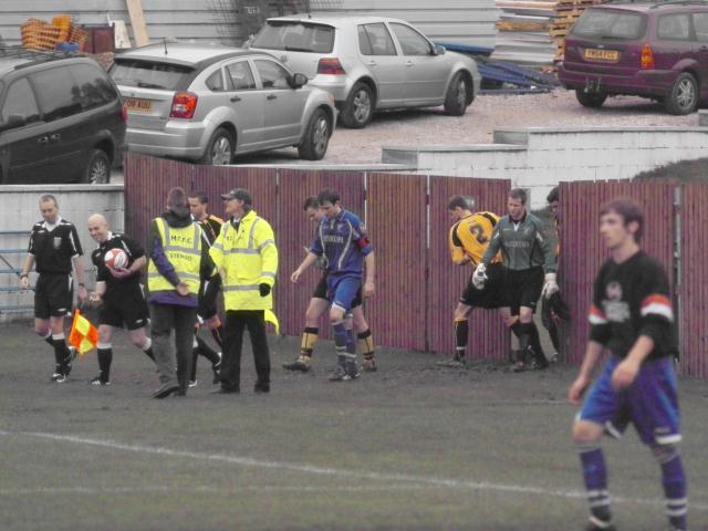 Onto the pitch through the gap in the fence