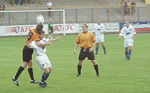 Len Curtis goes for a header